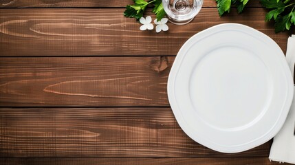 Empty white plate and elegant table setting with glass, flowers, and greenery on dark rustic wooden background
