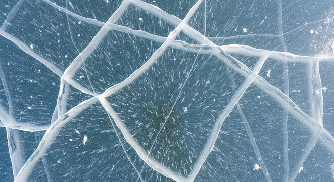 Cracked ice surface with intricate patterns and frozen texture in winter