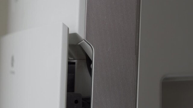 The plastic air purifier is turned on by pressing the 'Push' button. The startup is marked by a soft click and a beep, followed by the shutter rising and the sound of the fan starting increasing hum.