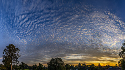 angle. Dramatic sunrise and sunset sky with vibrant clouds, showcasing warm and cool color contrasts in a panoramic view. inspiring travel planning.