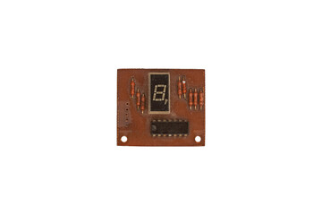Old brown circuit board with seven segment display and resistors is isolated.