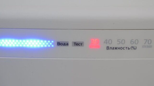 The plastic air purifier turns on with a single electronic beep, illuminating the indicator lights. The appliance then starts working, producing a gradually increasing hum of circulating air.