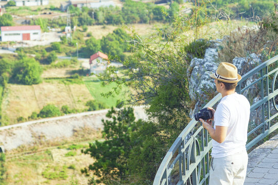 Traveler at scenic viewpoint near Herzegovacka Gracanica monastery with camera in hands. Symbol of mindful tourism, local culture appreciation, exploration of hidden Europe, and photography art.