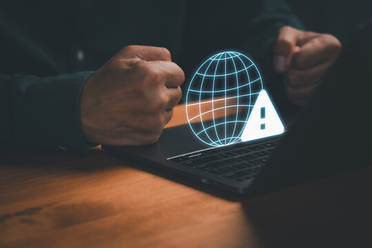 Internet connection error concept showing frustrated person with clenched fists near laptop and digital globe warning icon, representing network failure, online problem, and technology frustration.