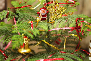Christmas tree with decoration. Close-up decorating Christmas tree with baubles balls on the background and santa claus small toy on tree and ball on tree. Christmas party or miracles and Santa Claus.