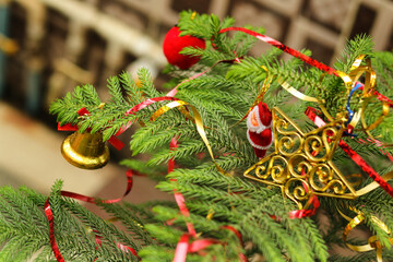 Christmas tree with decoration. Christmas party or miracles and Santa Claus. Close-up decorating Christmas tree with baubles balls on the background and santa claus small toy on tree and ball on tree.