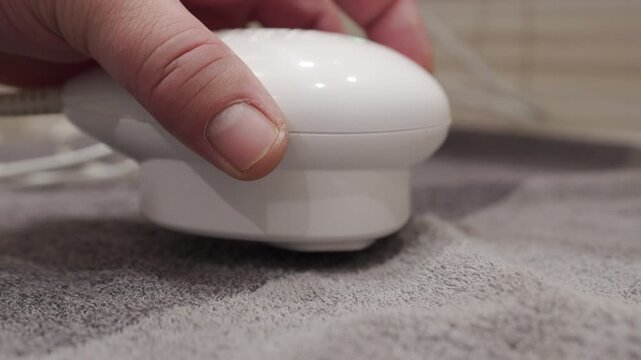 The handheld plastic therapy device is being operated. The device vibrates for treatment, producing a continuous rattling sound.