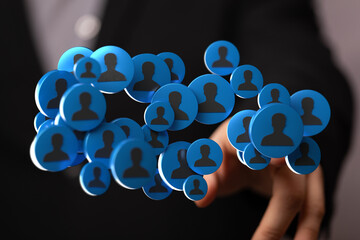 Abstract image representing a digital network, online connections, and communication. Hand reaching for blue circles with user silhouettes. Idea