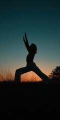 Silhouette of Woman Practicing Yoga at Sunset Outdoors