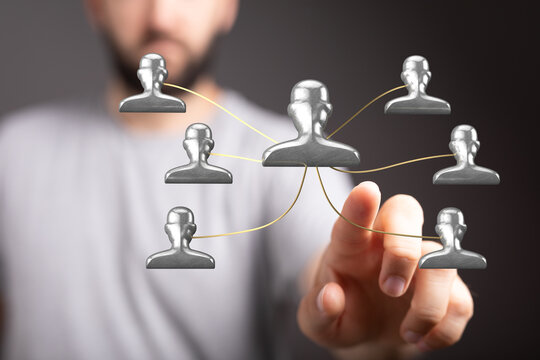 Close-up of a man's hand interacting with digital icons representing people in a network, business, social, or communication theme.