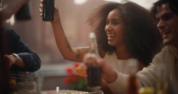 Diverse Group of Friends Enjoys a Rooftop Dinner Party, Sharing Laughter, Drinks, and Food. Woman With Curly Hair Raises a Toast, Joyful Togetherness and Celebration.