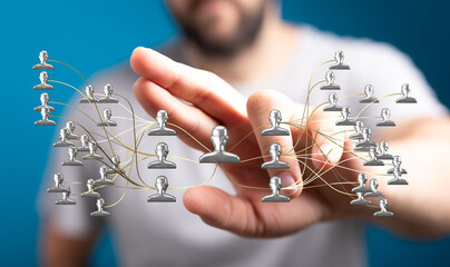 Close-up of a hand with a network of connected human figures, representing teamwork, collaboration,...
