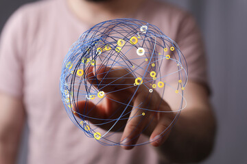 Close-up of a man's hand interacting with a digital globe, representing global connectivity and networks. Ideal for illustrating tech
