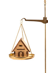 A symbolic wooden house on the scales