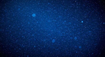 Abstract background of tiny blue particles floating in darkness, resembling dust motes or distant stars in a cosmic nebula