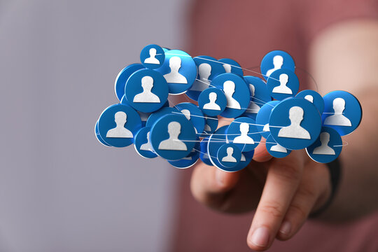 Hand touching network of people icons, representing social connections and teamwork. Concept for communication and global connectivity - Powered by Adobe