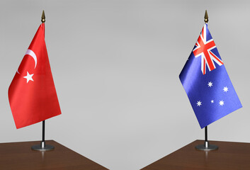 Table flags of Turkey and Australia on grey blurred background