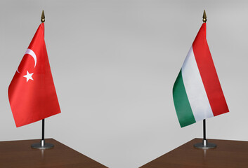 Table flags of Turkey and Hungary on grey blurred background