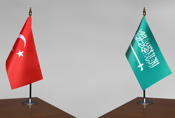 Table flags of Turkey and Saudi Arabia on grey blurred background
