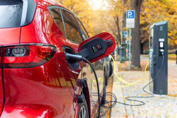 Close-up modern electric plug-in hybrid car SUV van parked   fast charger charging station point...