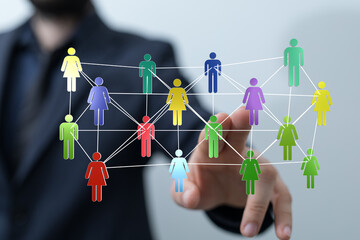 Concept of global connection, networking, teamwork, and social media. Hand pointing at a digital network of interconnected people icons.