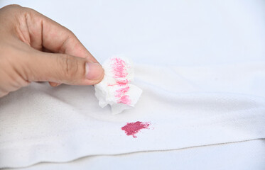 tissue remove dirty pink cosmetic stain on white shirt in daily life. stain for cleaning concept.