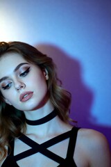 Captivating young woman with dramatic winged eyeliner and choker necklace bathed in vibrant blue and purple studio light, exuding modern elegance and allure.