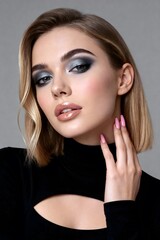 Stunning woman with dramatic smoky eye makeup and glossy lips, showcasing modern beauty and elegance in a studio portrait