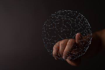 Abstract image of a person's hand holding a network sphere against a dark background, illustrating...