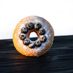 Fototapeta na wymiar Blueberry Donut with Powdered Sugar and Dramatic Backlighting