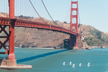 Golden Gate Bridge, a suspension bridge and landmark in San Francisco, spanning the Golden Gate channel at the mouth of San Francisco Bay, with multiple windsurfers sailing on the water