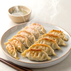 Pan-fried Japanese gyoza dumplings with crispy bottom, served with dipping sauce

