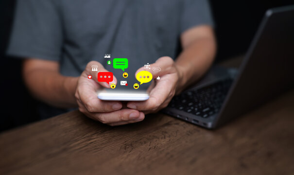 Person using smartphone with colorful chat bubbles and emojis, representing online communication, social media messaging, chat and digital connection.