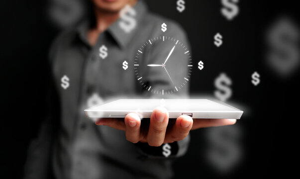 Businessman holding digital tablet with floating clock and dollar signs, symbolizing time management, financial success, and productivity in modern business.