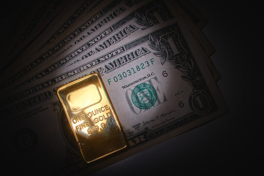 Gold ingot and us dollar bills representing wealth, finance, and investment