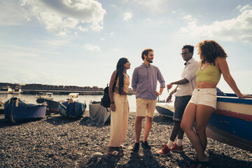 Friends enjoy a sunny day on the beach, sharing laughter and stories near colorful boats in the...