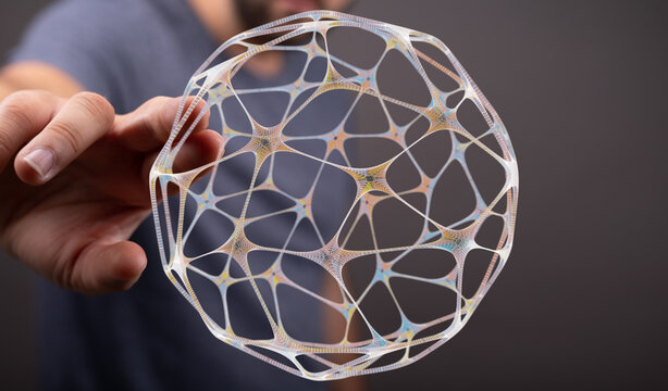 A close-up of a human hand holding a futuristic 3D sphere. Illustrating technology, innovation, and network with a touch of connectio
