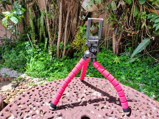 Red flexible mini-tripod at garden setting