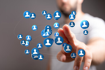 Hand touching network of user icons, representing connectivity, communication, and social interaction in the digital space. Focus on social medi