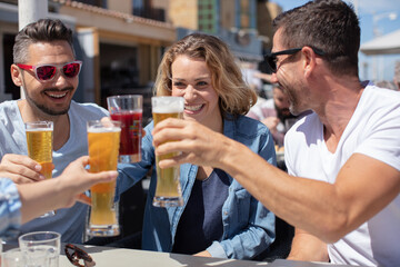 group of young friends drinking beer outdoors