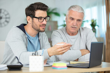 handsome senior and young businessmen using a laptop