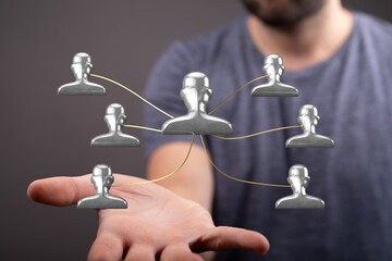 Hand holding a network of people representing connection, teamwork, and business networking. ...