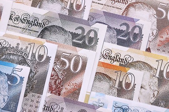 British pounds currency money bills in big amount. Many GBP currency banknotes with different denomination close up - Powered by Adobe