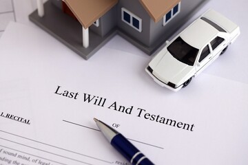 Generic toy house with car and Last will and testament with pen on table close up