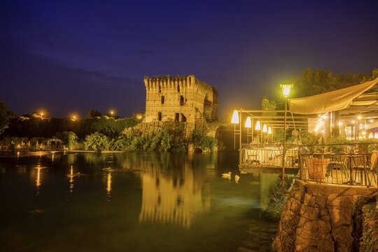 Night shot of restaurant on the Mincio river and Visconti bridge from 1395 in the background, Borghetto, Valeggio sul Mincio, province of Verona, Italy