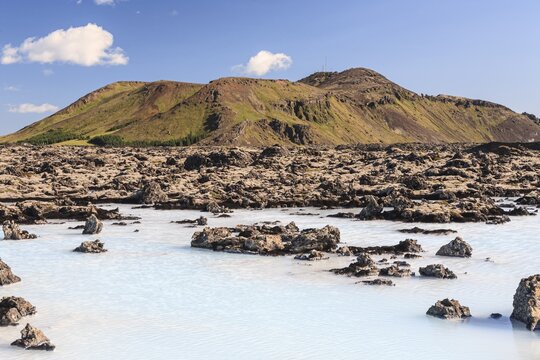 Thermal outdoor pool in front of volcanic mountains, Blue Lagoon, summer, sunny, Grindavik, Reykjanes, Iceland