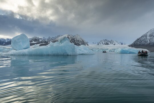 Dinghy with tourists, icebergs in front of glacier, -edge of Monacobreen, Liefdefjord, Woodfjord area, Spitsbergen Island, Svalbard and Jan Mayen archipelago, Norway