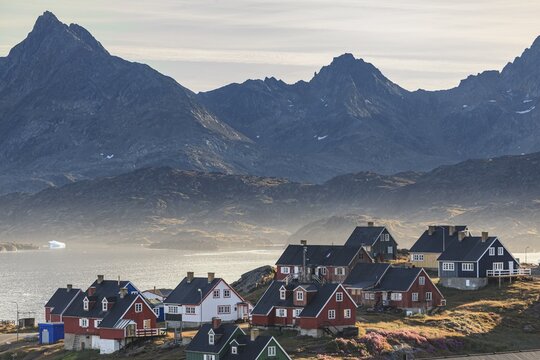 Typical Greenlandic houses on a fjord with steep mountains, Inuit settlement, autumn, Tasiilaq, East Greenland, Greenland