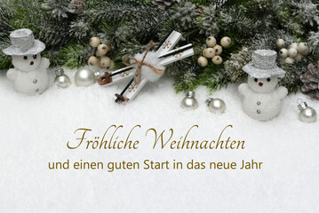 Weihnachtskarte: Winterliche Kulisse mit Schneemann, Ski und Weihnachtskugeln im Schnee.Im Schne...