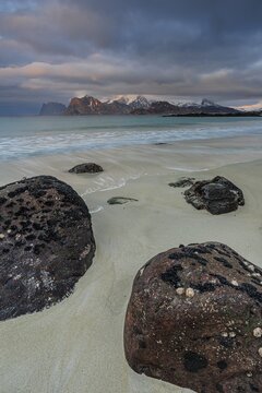 Rocks and beach in front of Bergen, sea, surf, spray, clouds, winter, Flakstadoya, Lofoten, Norway
